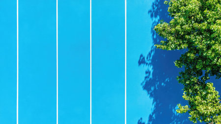 A stunning aerial view captures a blue tennis court contrasted by a lush green tree, creating a vibrant scene of outdoor sports and nature. Perfect for recreational themes.の素材