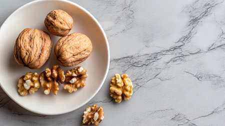 A stylish arrangement of whole and shelled walnuts on a smooth stone background, highlighting their textures, perfect for promoting healthy eating and gourmet presentations.の素材