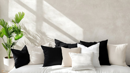 A stylish living room scene showcasing a minimalist design with decorative cushions in black and white, complemented by a touch of greenery, perfect for relaxation and comfort.の素材