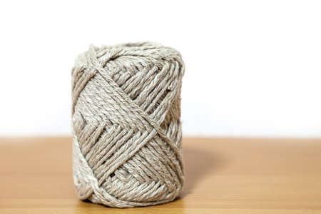 Ball of brown yarn on white background