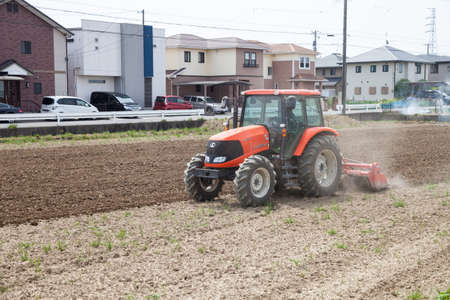 NAGOYA, JAPAN - April 16, 2016: Farmer in tractor preparing land for sowing. Farmer in tractor preparing land with seedbed cultivator.のeditorial素材