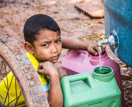 Nakhon Ratchasima,THAILAND - March 4: Unidentified  Asian boy Saving water for use it in the family in summer no March 4,2016 in Khong district,Nakhon Ratchasima,THAILAND.のeditorial素材