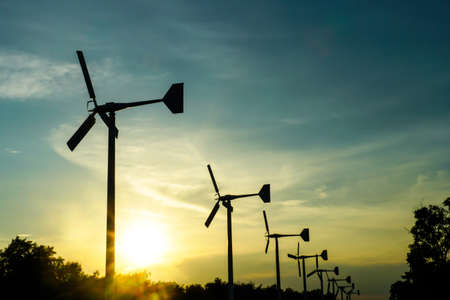 Beautiful sunset above the windmills on the field , Wind turbine power generator with sunsetの写真素材