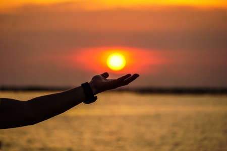 Woman making of hands at sunset,Sunset over the sea.の写真素材