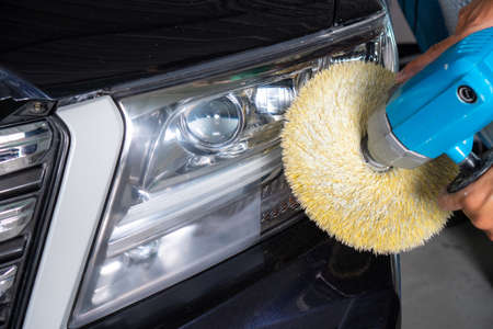 Big headlight cleaning with power buffer machine at service station ,Before and after cleaningの写真素材