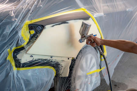 Repairing car body by puttying close up work after the accident by working sanding primer before painting. , The mechanic repair the car  , Using plastic putty ,Prepare surface for spray paintingの写真素材
