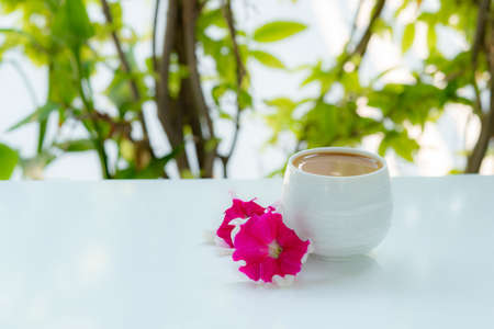 Cup of coffee and red flower on Natural background