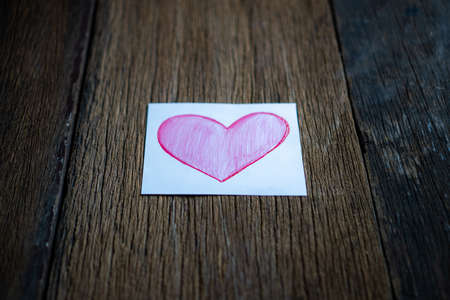 Pink paper heart on a wooden tableの写真素材
