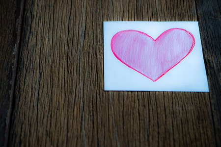 Pink paper heart on a wooden tableの写真素材