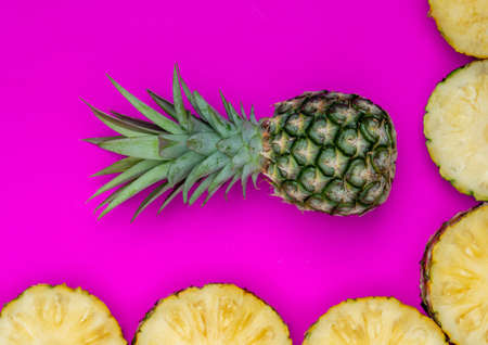 Pineapples on pink background. Pattern made of sliced pineapples. Flat lay, top viewの写真素材