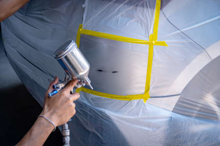 Repairing car body by puttying close up work after the accident by working sanding primer before painting. , The mechanic repair the car  , Using plastic putty ,Prepare surface for spray paintingの写真素材