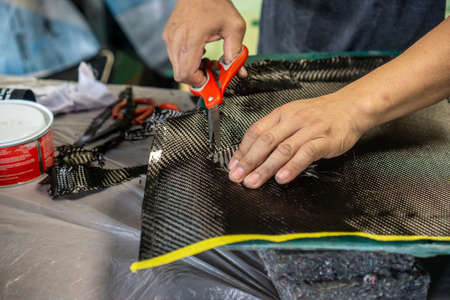 Auto mechanic is making car parts from carbon., The hood (front bonnet ) is made of carbon.