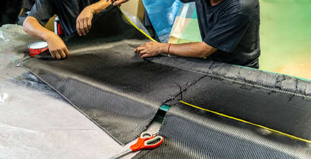 Auto mechanic is making car parts from carbon., The hood (front bonnet ) is made of carbon.