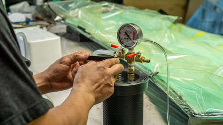 Auto mechanic is making car parts from carbon., The hood (front bonnet ) is made of carbon.