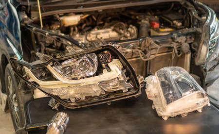 Car mechanic, doing cleaning, The headlight of the car, installation and turning headlight of modern automobile and car projector lens. Vehicle head xenon lamp in details. Concept of auto detailing, light and LED technologyの写真素材