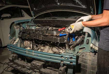 Mechanic worker repairman fixing by sanding polishing car body and preparing for painting at station service.の写真素材
