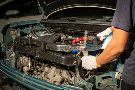 Repairing car dents with a hammer and knock ,Make the surface of the car smooth ,preparing for painting at station service.の写真素材