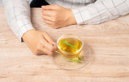 Woman drinking tea made from cannabis leaves ,A cup of hot marijuana tea with buds and leaves.の写真素材