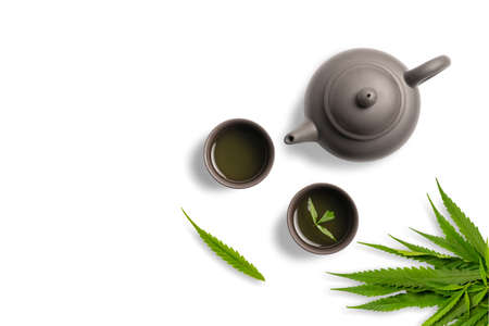 Tea made from cannabis leaves ,A glass of hot marijuana tea on white background , tea pot and cups on white backgroundの写真素材