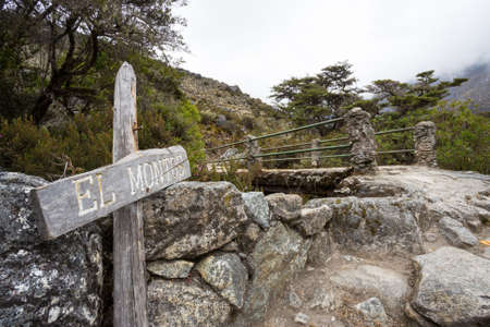 path with a pedestrian bridge to El Montos in Venezuelan Andes, indication with the text "El Montos" means community El Montosの写真素材
