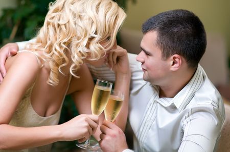 Young couple celebrating with champagne together, in restaurantの写真素材