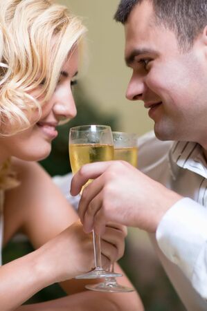 Cheerful young couple drinking champagne in a restaurantの写真素材