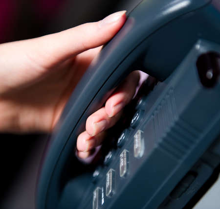 Woman's hand holding telephone receiver の写真素材