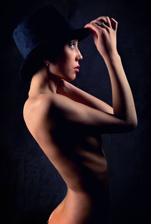 Beautiful woman wearing black hat posing indoorsの写真素材