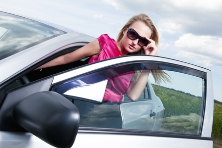 Young beautiful woman posing near the carの写真素材
