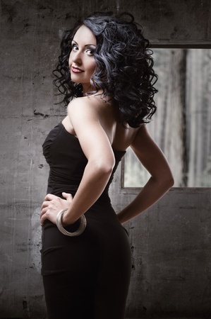 Beautiful woman wearing black dress posing indoorsの写真素材