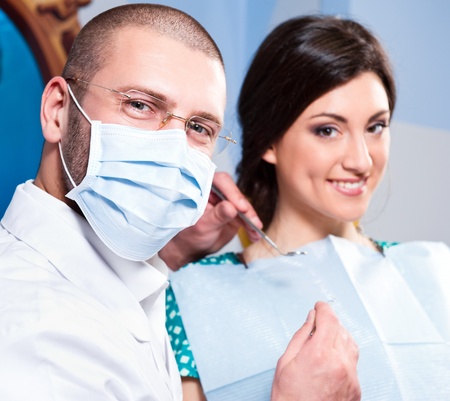 Friendly male dentist with smiling patient at dental clinicの写真素材