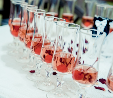 Glass of pink champagne with cherry close-upの写真素材