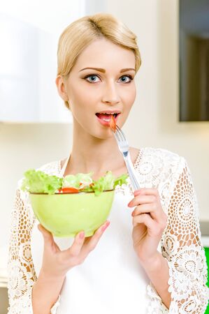 Portrait of a beautiful young woman eating vegetable salad  Dieting Concept  Vegetarian foodの写真素材