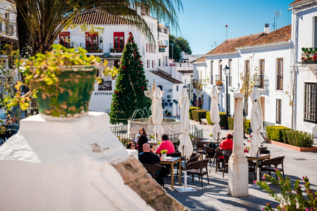 Mijas, Spain- January 5, 2014: Tourists sitting in a sidewalk cafe on central street of Mijas. Mijas is a lovely Andalusian white village on the Costa del Sol. Spainのeditorial素材