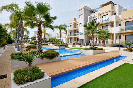 Torrevieja, Spain - October 28, 2019: Modern apartments with swimming pool cozy decorated leisure area, sunny warm day. Real estate purchasing, loan mortgage, new dwelling conceptのeditorial素材