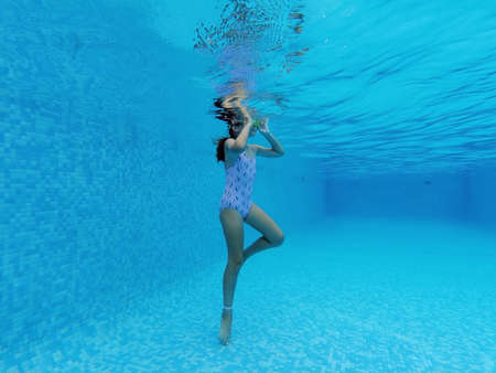 Full length view little 7 - 8 years old girl wear swimsuit and goggles enjoy summer vacations...
