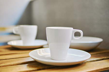 Two white tea cups on table in terraced area, no peopleの写真素材