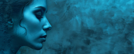 Side profile face view of attractive young woman on bright blue grunge wall background. Beauty, cosmetology conceptの素材