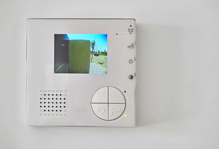 Concept of home automation smart modern luxury wealthy home. On white wall home video intercom with...