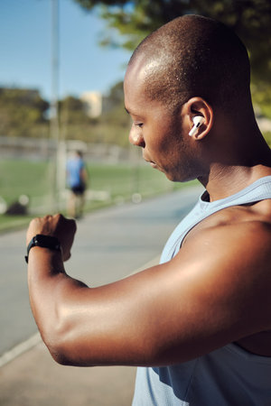 Young athletic man, soccer player sit, resting outdoors in sports field, wearing sleeveless shirt,...