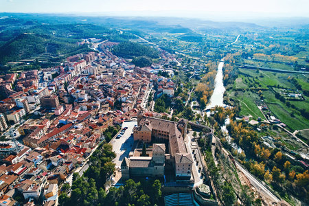 Aerial view of ancient town of Alcaniz, located in Teruel, Spain. Castle of the Calatravos, perched on hilltop, surrounded by historical buildings and modern urban structures.の写真素材