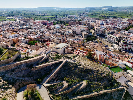 Curvy road goes up hill of San Miguel Diocesan Seminary and view to the Orihuela townscape. Costa Blanca, province of Alicante. Spainの写真素材