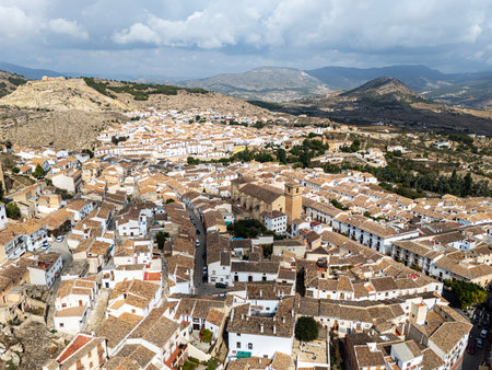 Scenic aerial view of historic town of Velez-Blanco in southern Spain, traditional whitewashed houses, central church, and dramatic mountain landscapes in backgroundの写真素材
