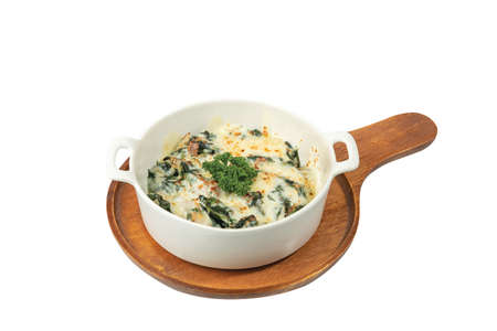 Baked Spinach with Cheese in white plate on wooden tableの写真素材