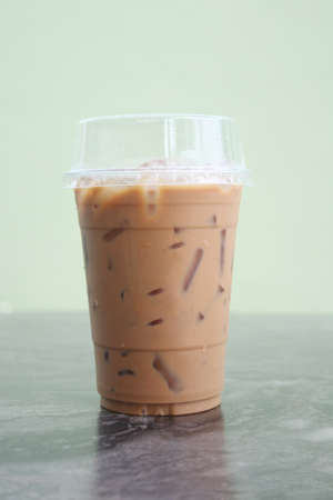Iced coffee glass on the marble table with green backgroundの写真素材