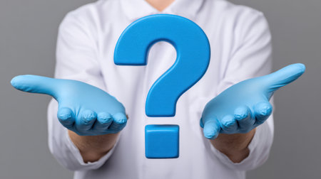 A person wearing blue gloves is holding a large blue question mark, representing uncertainty and the search for answers in healthcare and inquiries.の素材
