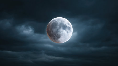A breathtaking view of a full moon casting its glow through dark, stormy clouds. This captivating scene captures the beauty of nighttime skies and celestial wonders.の素材