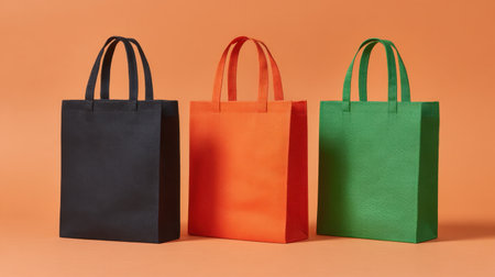 A vibrant collection of reusable shopping bags displayed on a bright orange background. The bags highlight sustainability and practical design, perfect for eco-conscious consumers.の素材