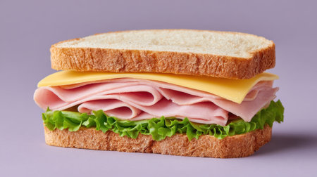 A delicious sandwich layered with ham, cheese, and crisp lettuce, served between two slices of whole wheat bread. Ideal for lunch or a snack.の素材