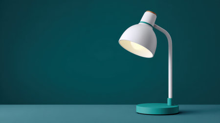 A sleek modern desk lamp positioned on a teal background, casting soft shadows that enhance the cozy feel of any workspace or study area.の素材